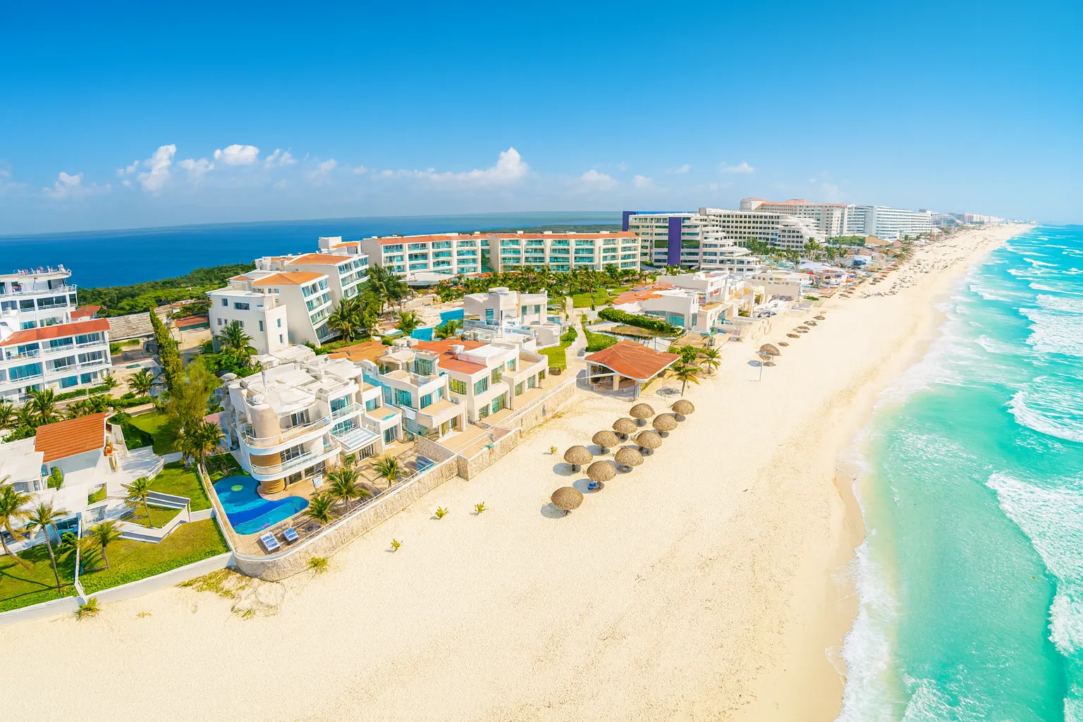 Aerial view of a luxury resort with pools surrounded by palm trees
